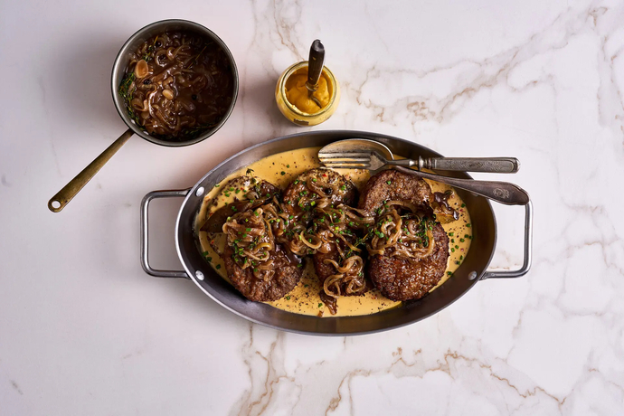 Jauhelihapihvit, ruskistettua sipulia ja pippurikastiketta