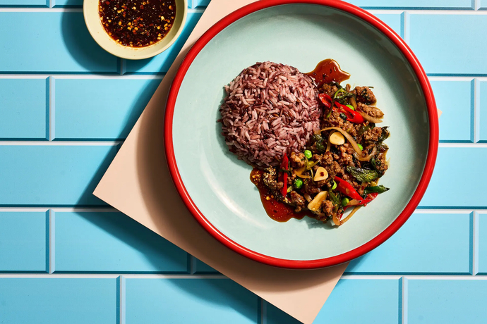 Thaimaalainen paistettu jauheliha, chiliä, herneitä ja violettia riisiä