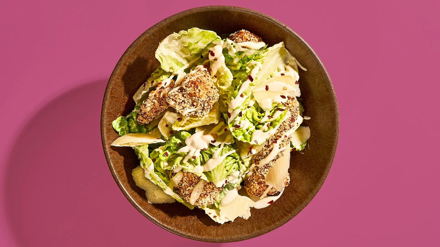 Punertavalla taustalla lautanen, jossa on Kot Spot Caesar-annos.