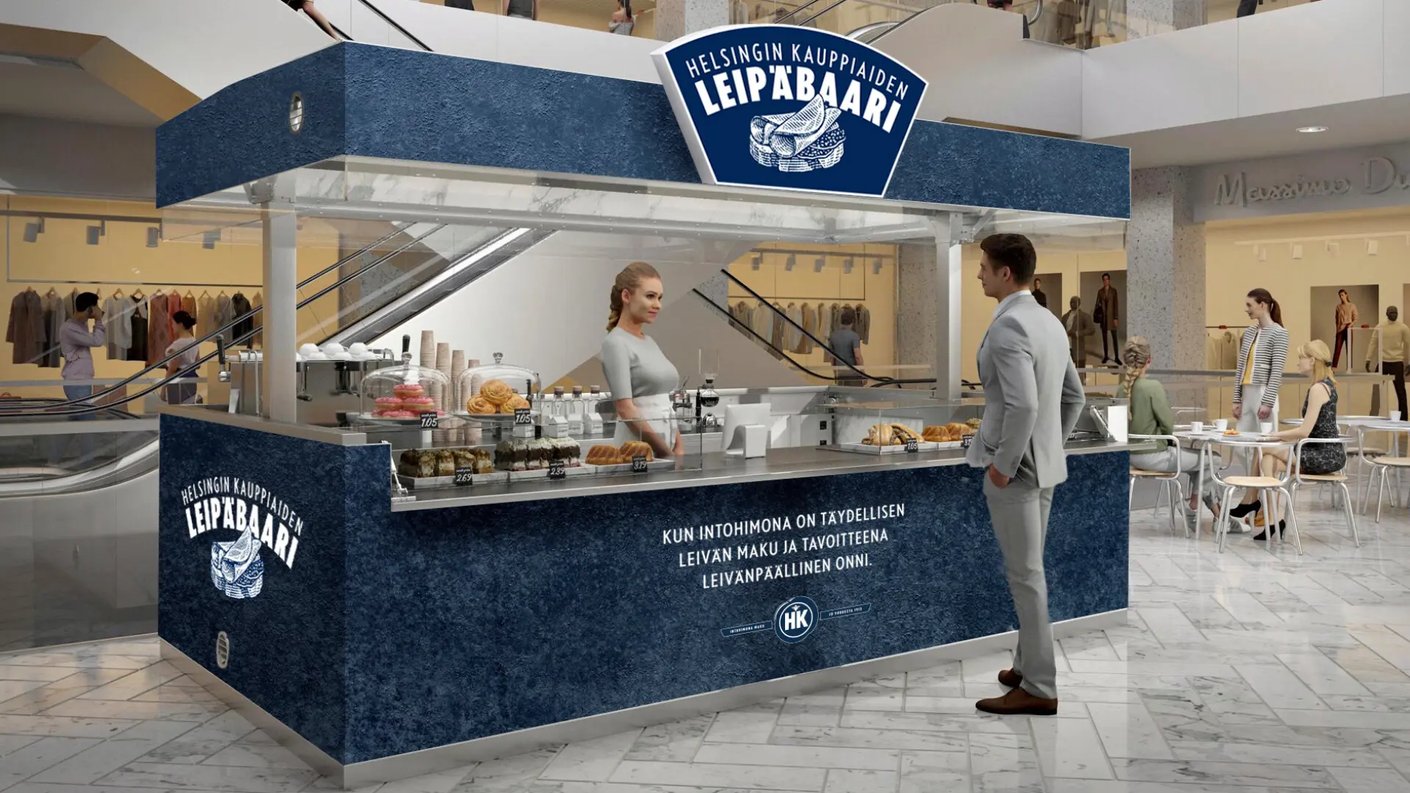 HK Leipäbaari-myyntipiste, jossa nuori nainen myymässä. Asiakkaana mies puku päällä. 