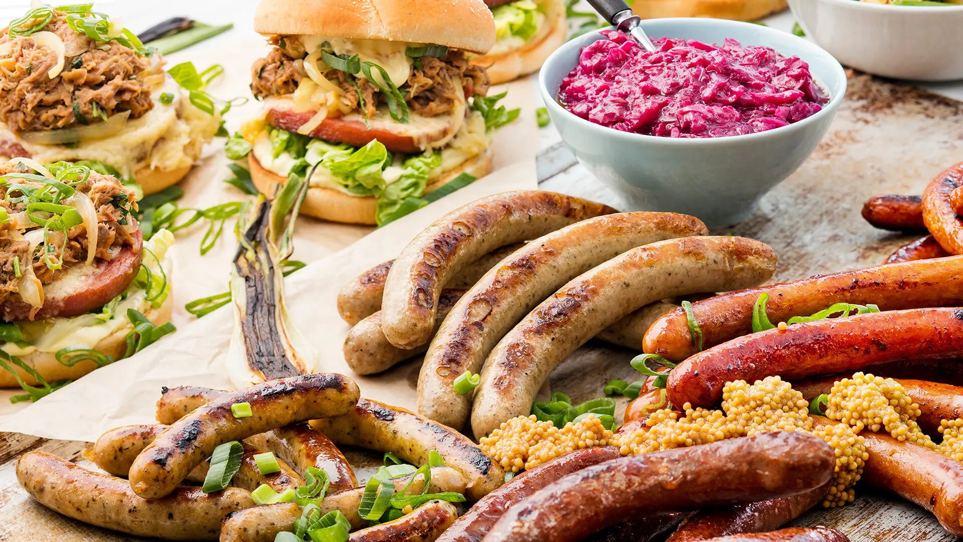 Erilaisia makkaroita, hampurilaisia, sinapinsiemeniä ja punakaalia.