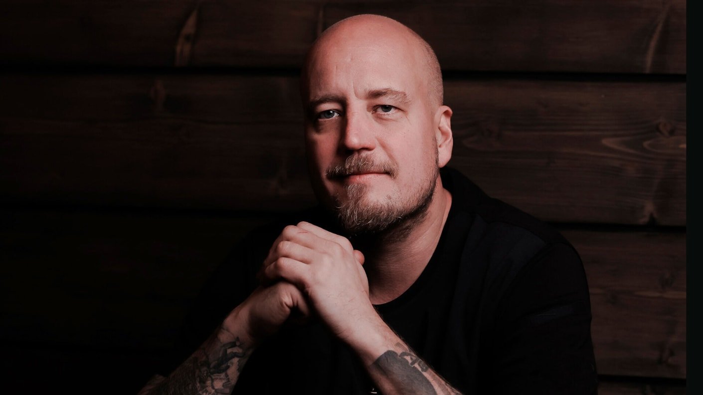 Tumma kuva, jossa Miilu Resortin Keittiömestari Alex Räsänen katsoo kuvaajaa.